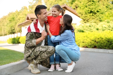 Man in military uniform and his family outdoors