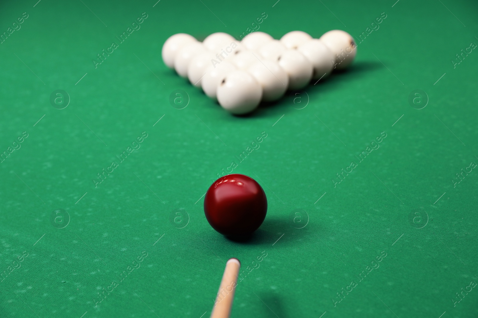 Photo of Striking billiard ball with cue on table