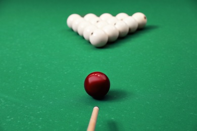 Photo of Striking billiard ball with cue on table