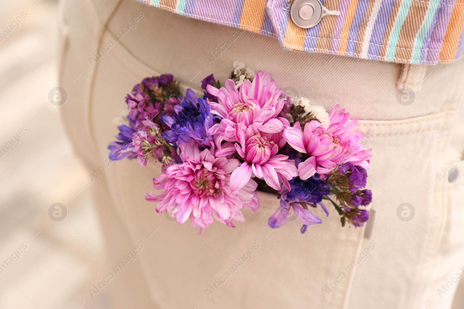 Photo of Woman wearing jeans with flowers in pocket, closeup