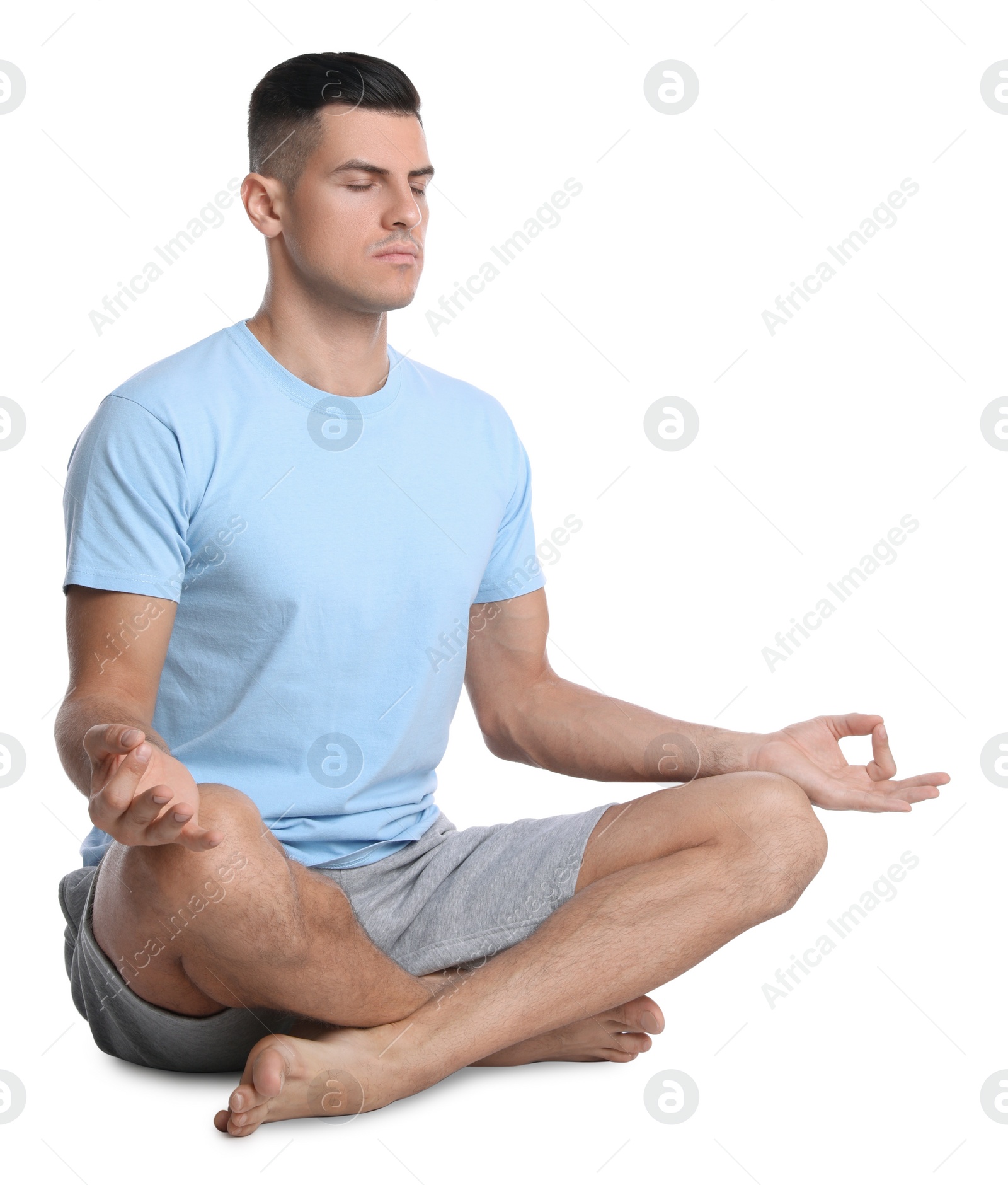 Photo of Handsome man meditating on white background. Harmony and zen