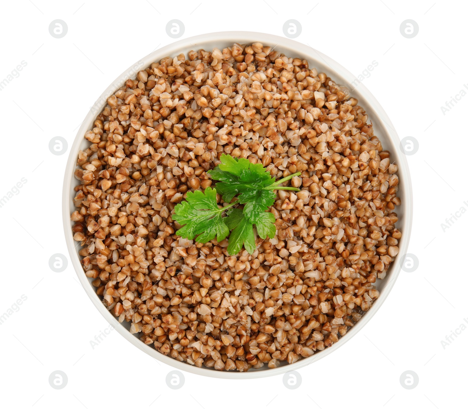 Photo of Plate of buckwheat porridge with parsley isolated on white, top view