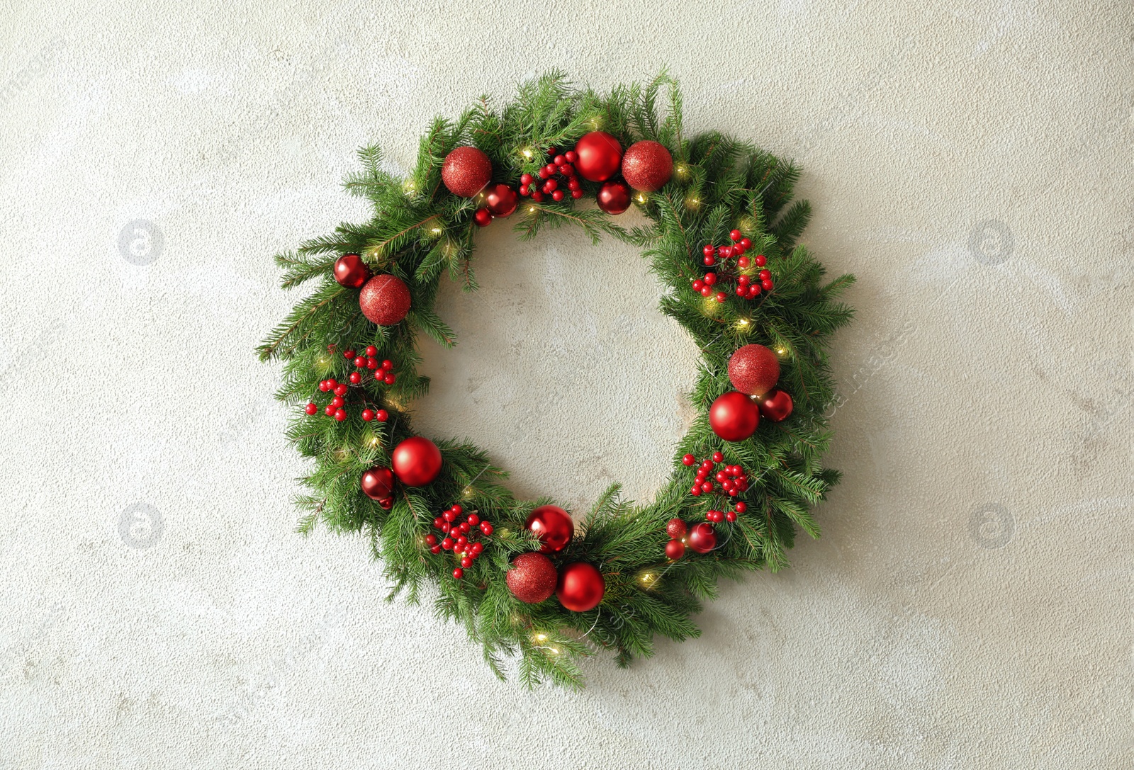 Photo of Beautiful Christmas wreath with festive decor on light wall