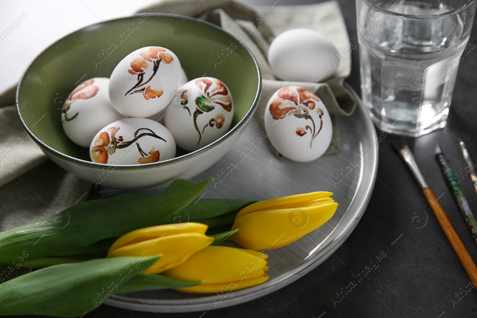 Photo of Composition with painted Easter eggs on dark table