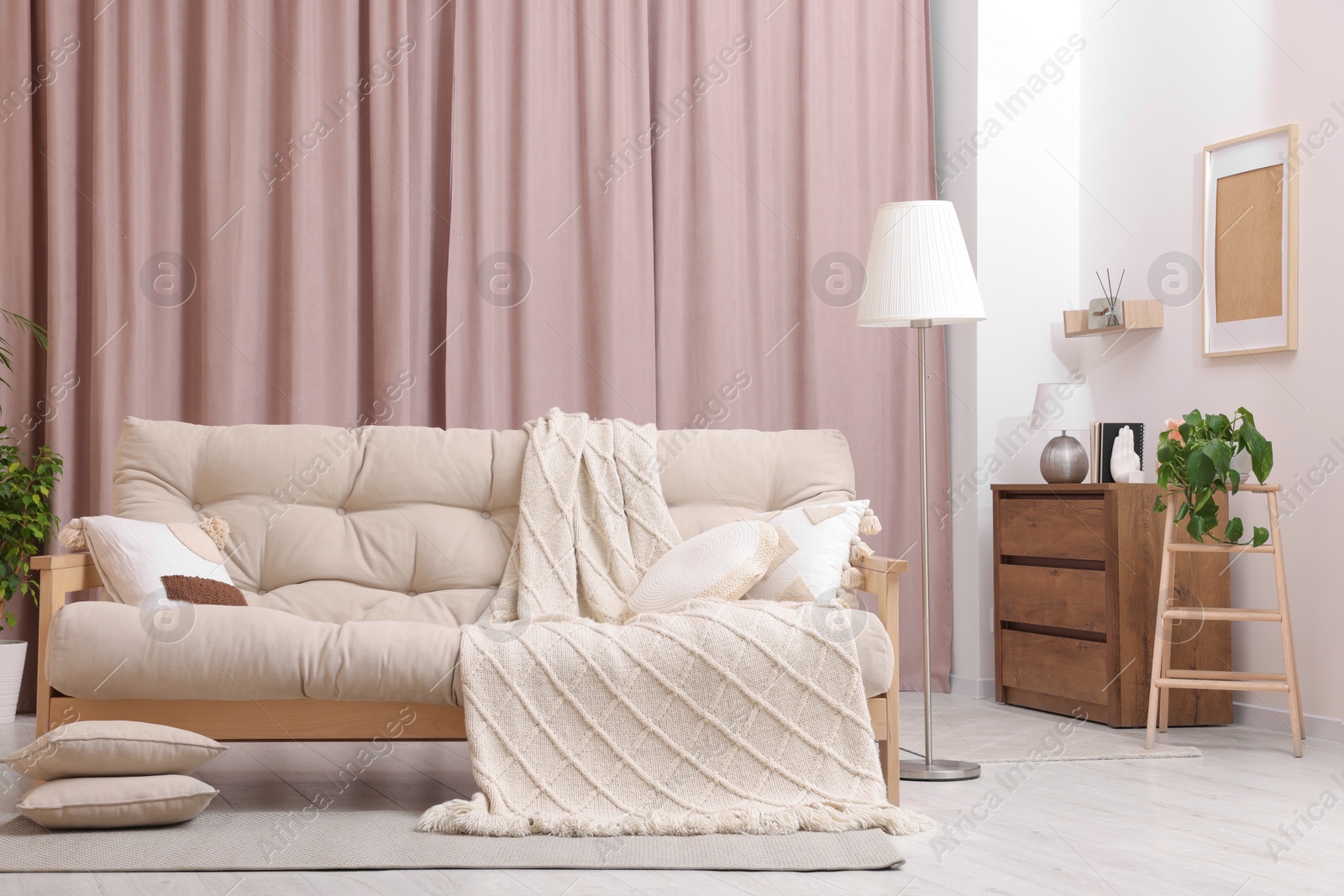 Photo of Comfortable sofa, cushions and blanket in cozy room. Interior design