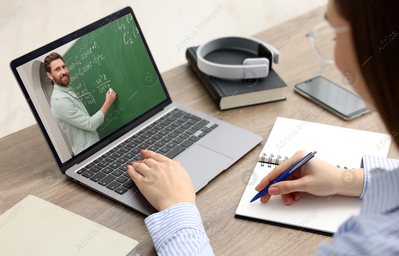 Image of E-learning. Young woman having online lesson with teacher via laptop at home