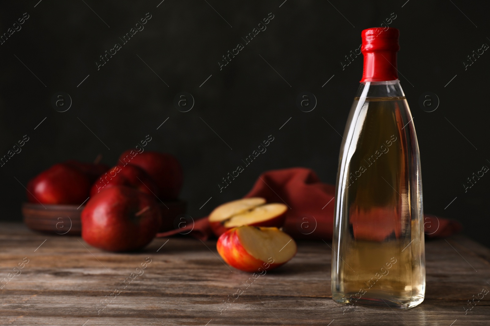 Photo of Composition with bottle of apple vinegar on table. Space for text