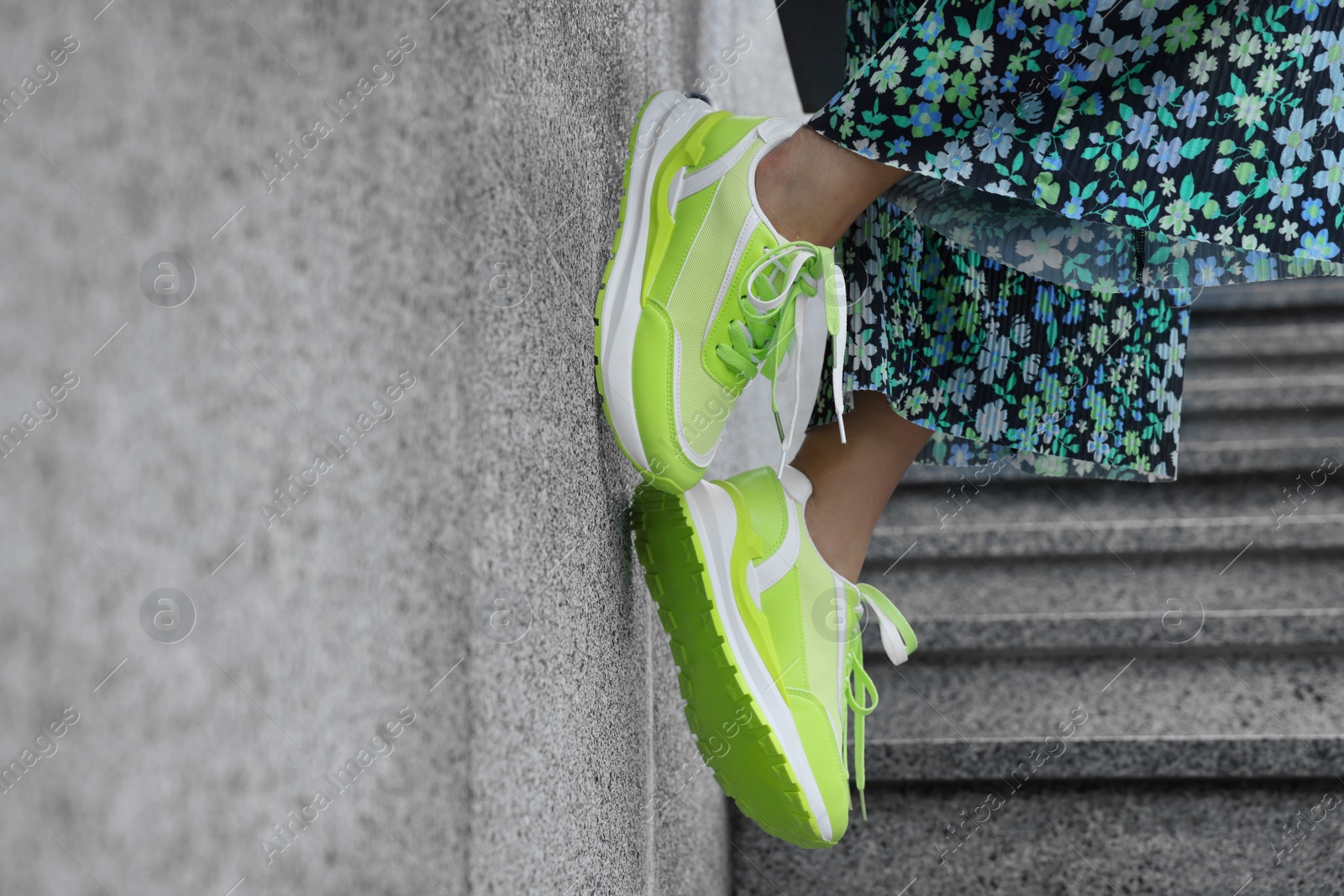 Photo of Woman wearing stylish sneakers outdoors, closeup. Space for text