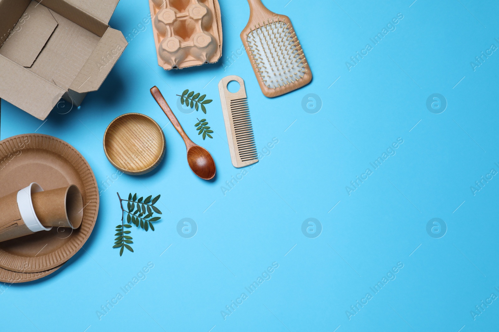 Photo of Different eco items on light blue background, flat lay with space for text. Recycling concept