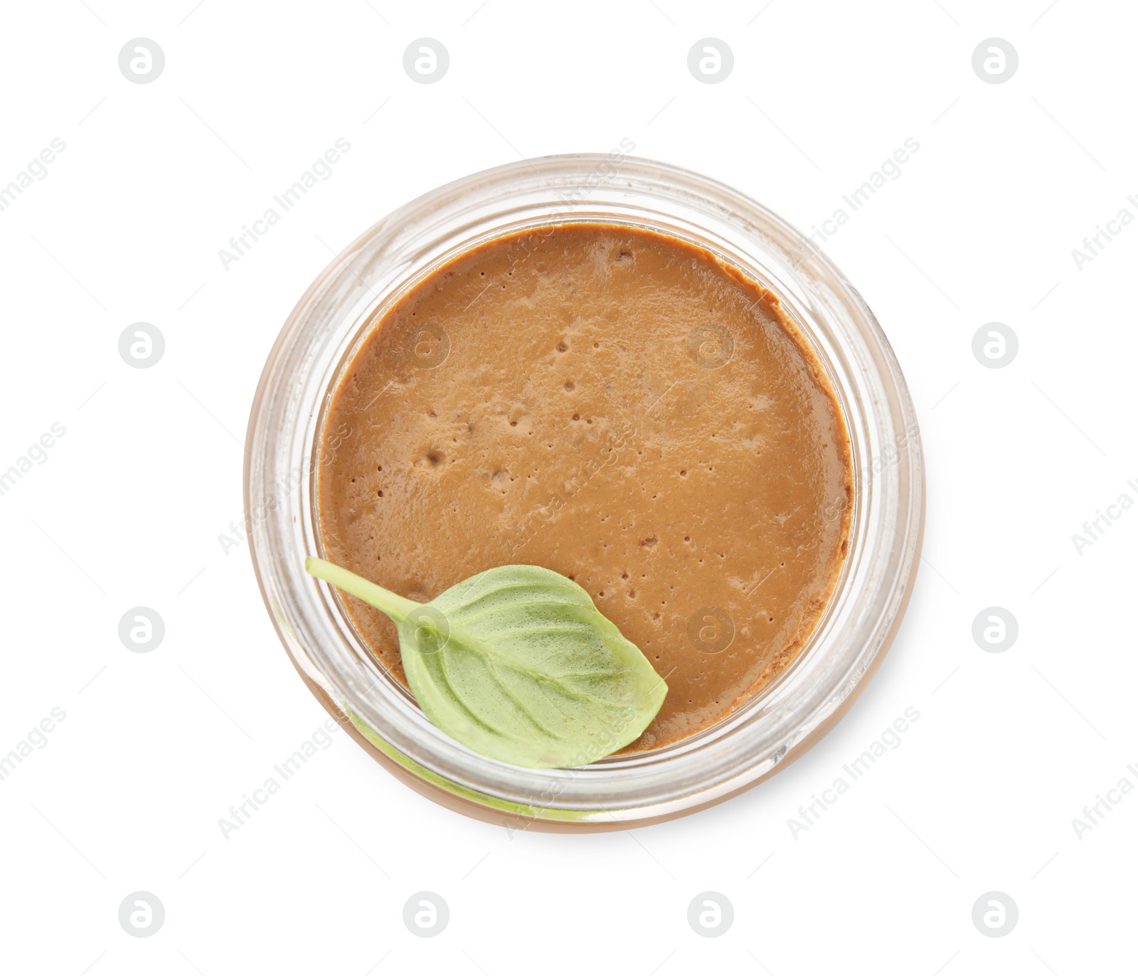 Photo of Delicious meat pate and basil leaf in glass jar isolated on white, top view