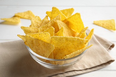 Photo of Tortilla chips (nachos) in bowl on white wooden table, closeup