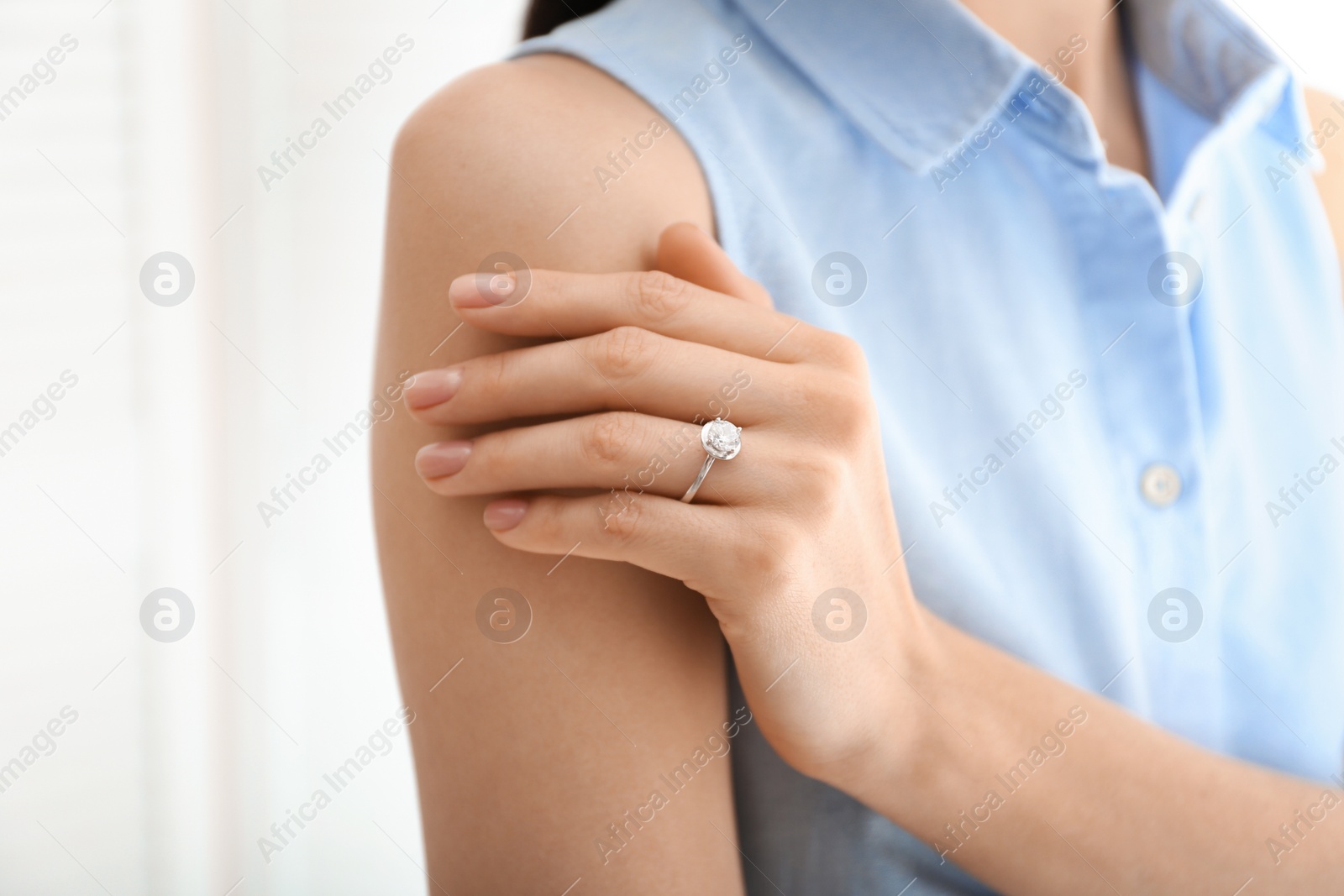 Photo of Young woman wearing beautiful engagement ring, closeup