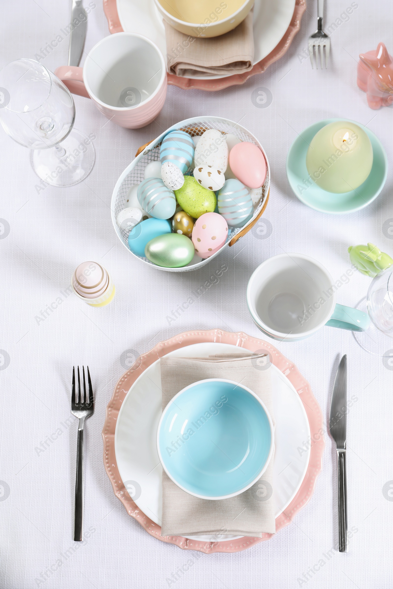 Photo of Festive table setting with painted eggs, flat lay. Easter celebration