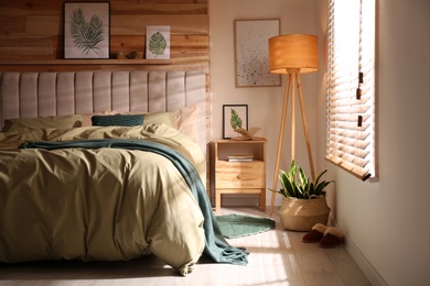 Comfortable bed with new pistachio linens in modern room interior