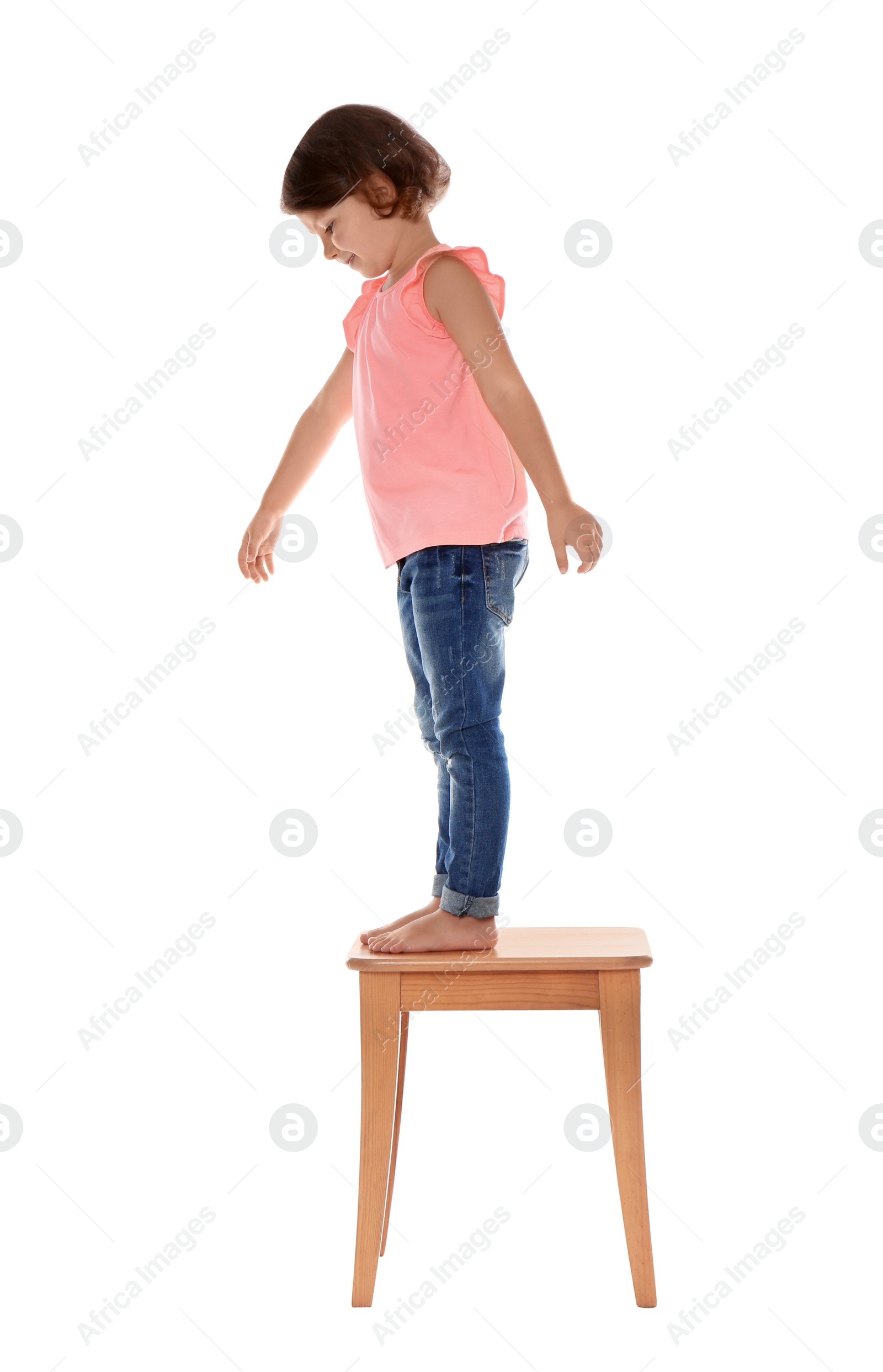 Photo of Little girl on stool against white background. Danger at home