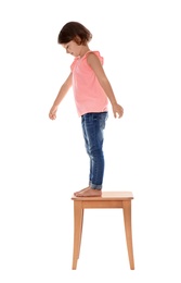 Little girl on stool against white background. Danger at home