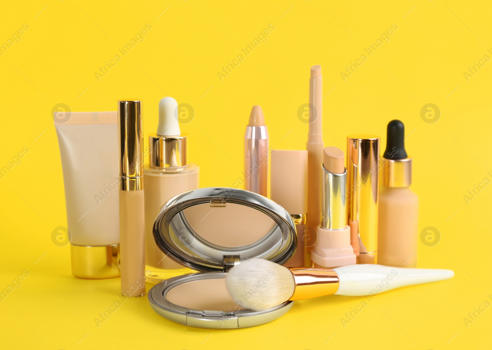 Photo of Foundation makeup products on yellow background. Decorative cosmetics