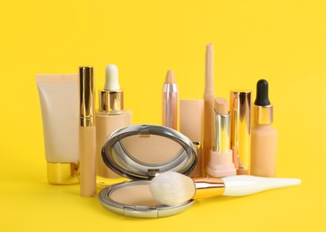 Photo of Foundation makeup products on yellow background. Decorative cosmetics