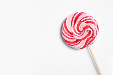Stick with bright lollipop on white background, top view. Space for text