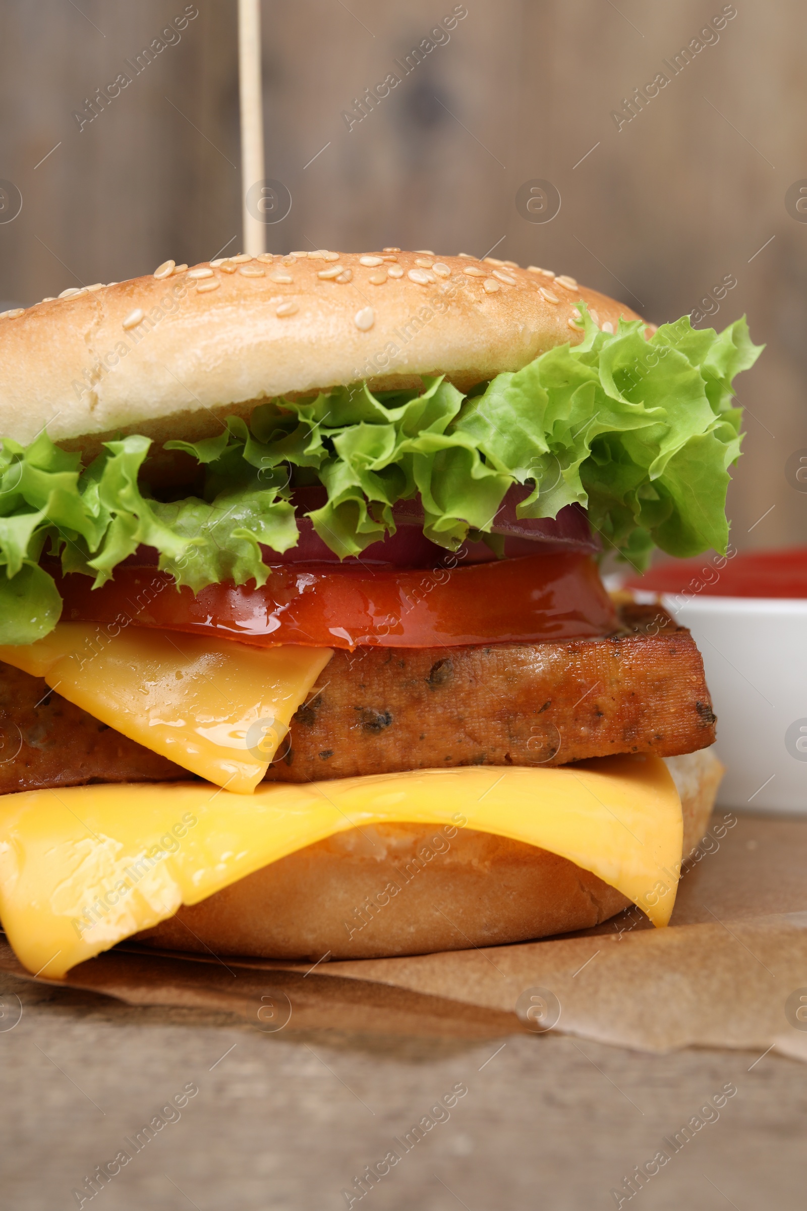 Photo of Delicious burger with tofu and fresh vegetables on table, closeup