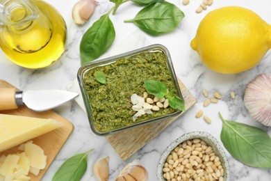 Photo of Flat lay composition with delicious pesto sauce and ingredients on white marble table