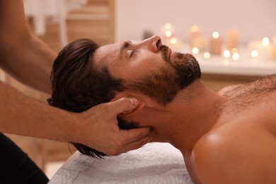 Photo of Man receiving professional neck massage in spa salon