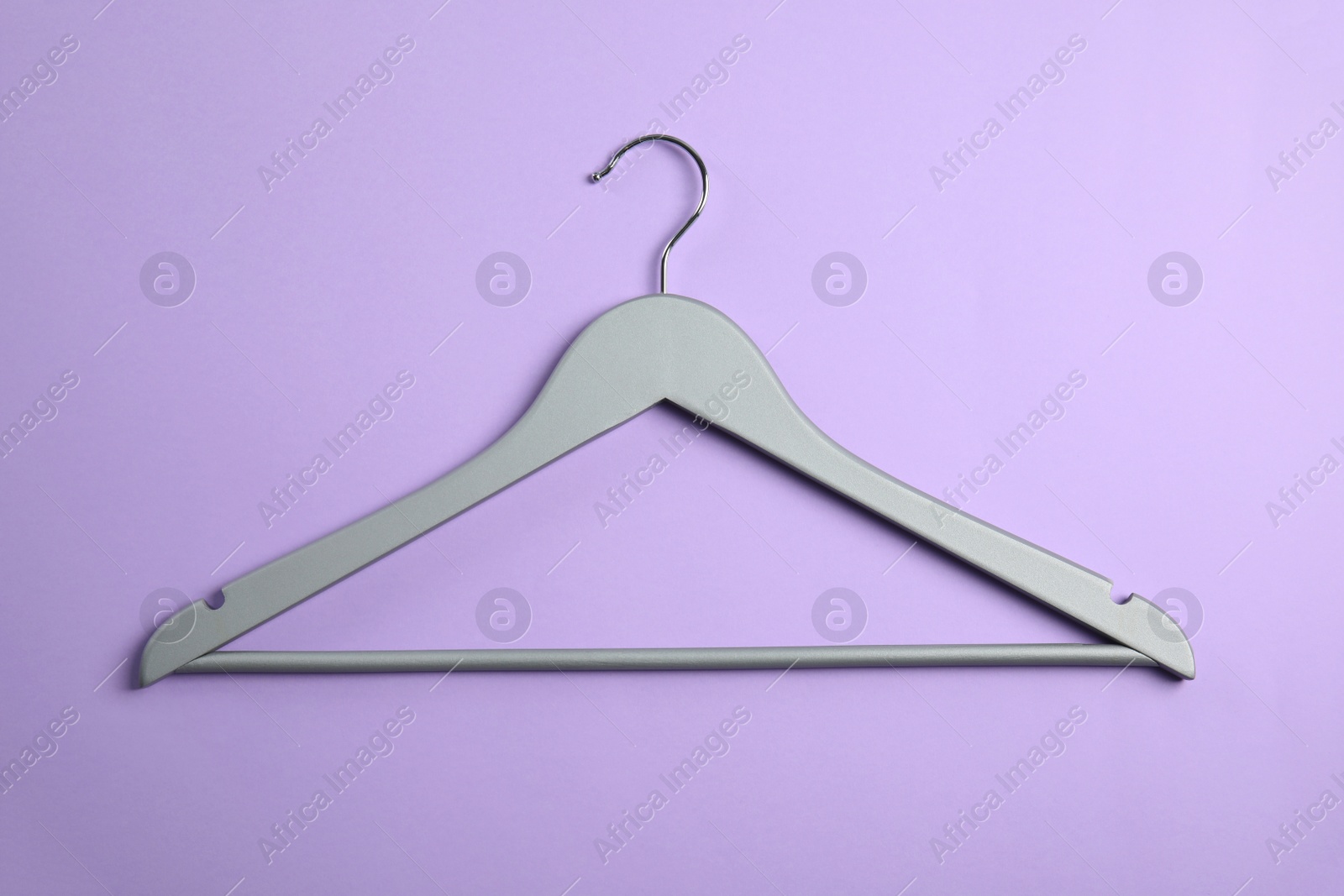 Photo of Empty wooden clothes hanger on color background, top view