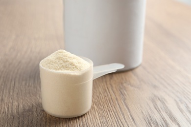 Scoop of protein powder on wooden table