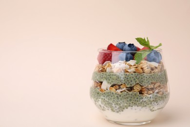 Photo of Tasty oatmeal with chia matcha pudding and berries on beige background, space for text. Healthy breakfast