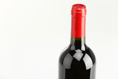 Photo of Bottle of expensive red wine on white background, closeup. Space for text