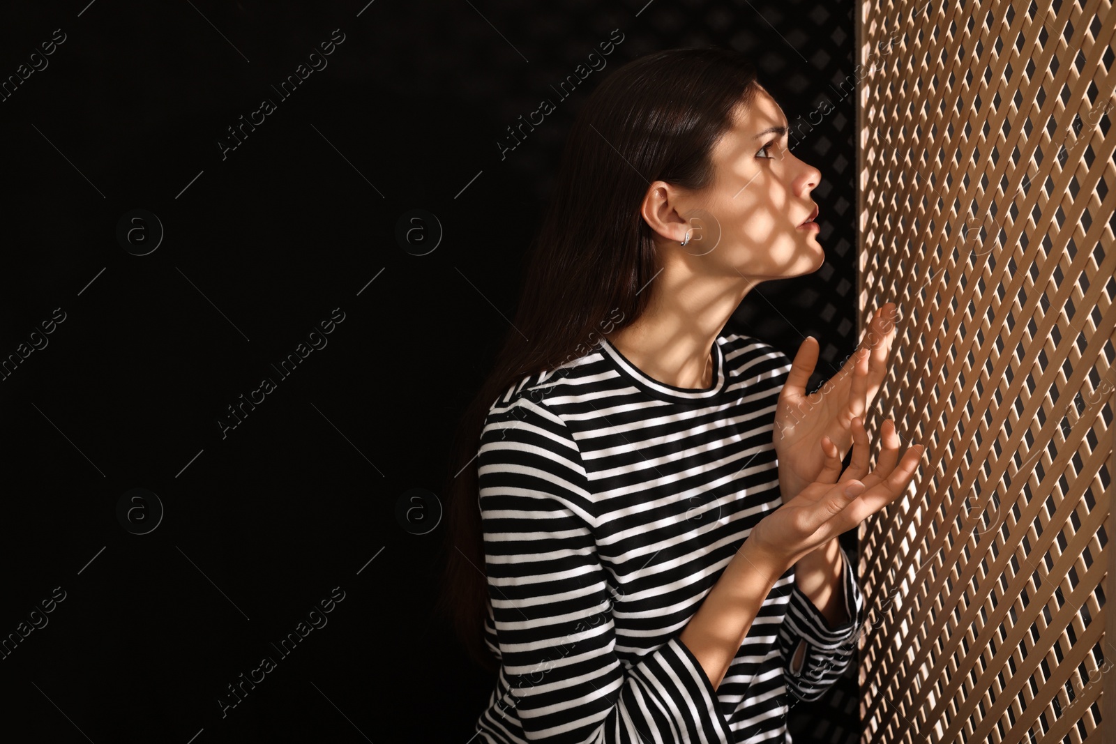 Photo of Woman talking to priest during confession near wooden partition in booth, space for text