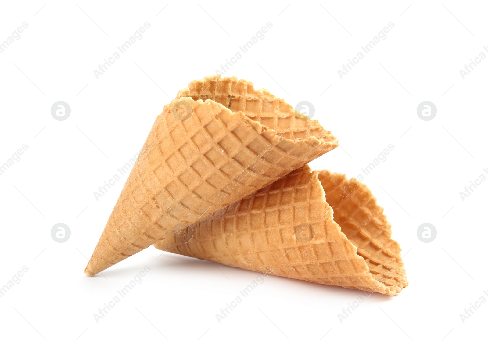 Photo of Empty crispy waffle cones for ice cream on white background