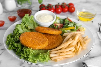Photo of Delicious fried breaded cutlets with garnish served on white marble table
