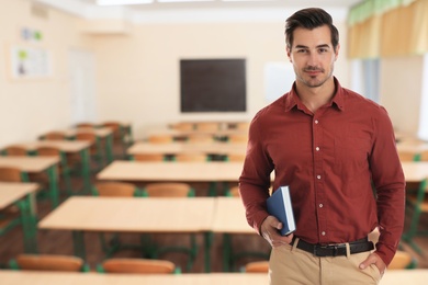 Young school teacher waiting for students in classroom
