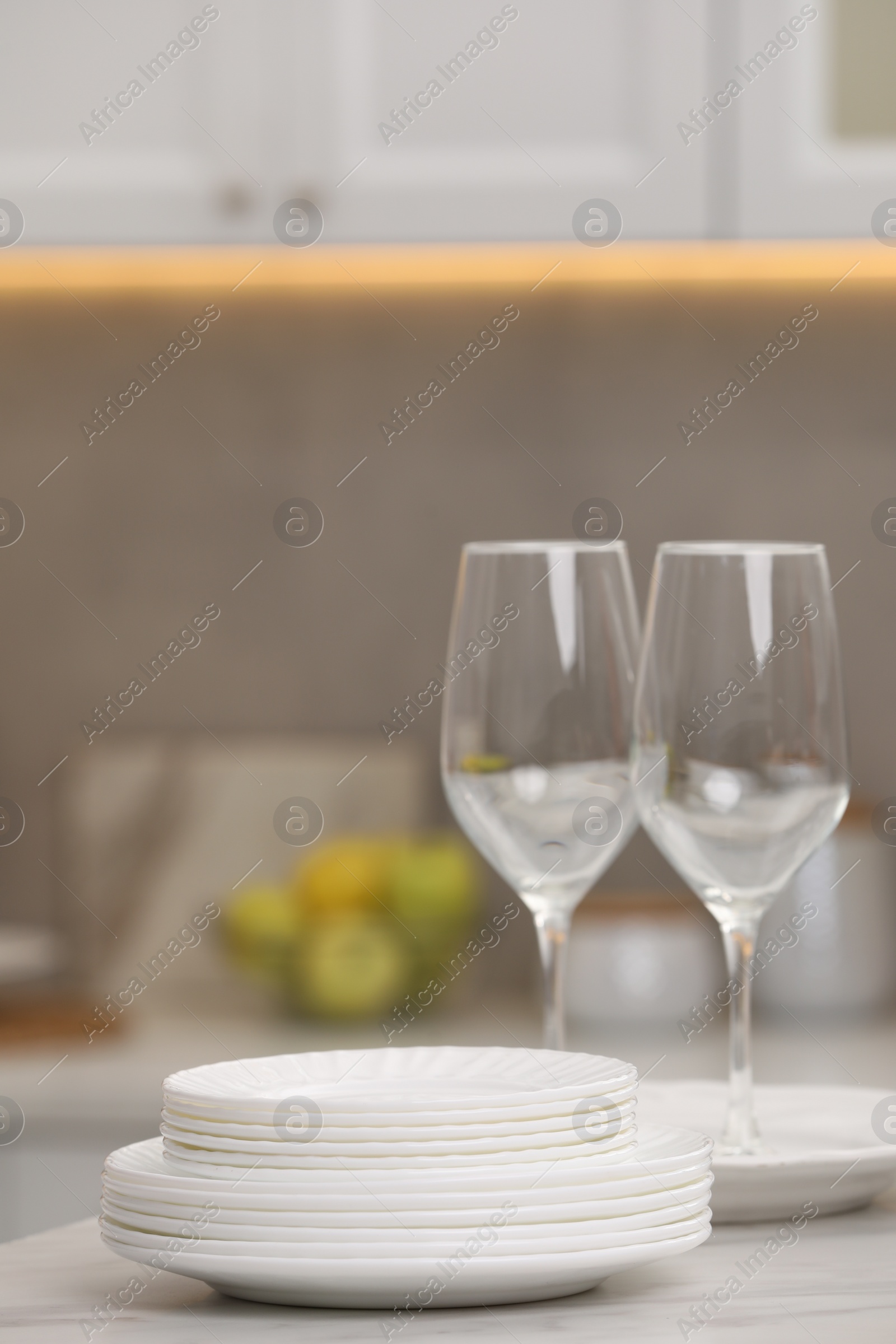 Photo of Clean dishes on light table in kitchen, space for text