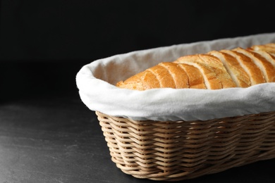 Slices of bread in basket on black table