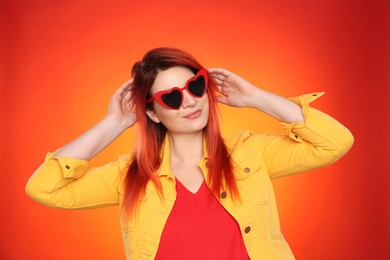 Young woman with bright dyed hair on color background