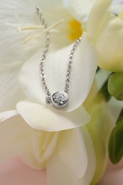 Photo of Beautiful necklace with gemstone on flower, closeup. Luxury jewelry