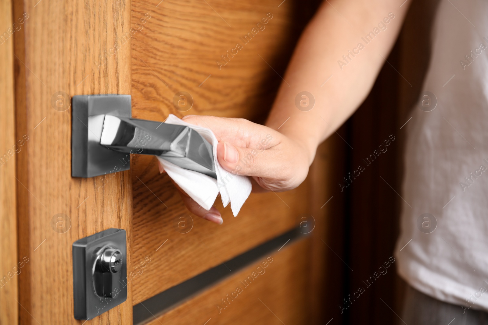 Photo of Woman using tissue paper to open door, closeup