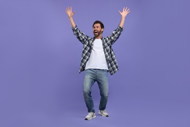 Photo of Emotional sports fan celebrating on purple background