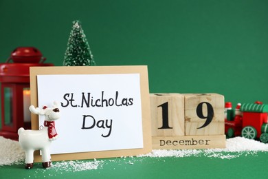 Photo of 19 December Saint Nicholas Day. Block calendar, card and festive decor on green background