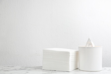 Photo of Clean paper tissues on white marble table. Space for text