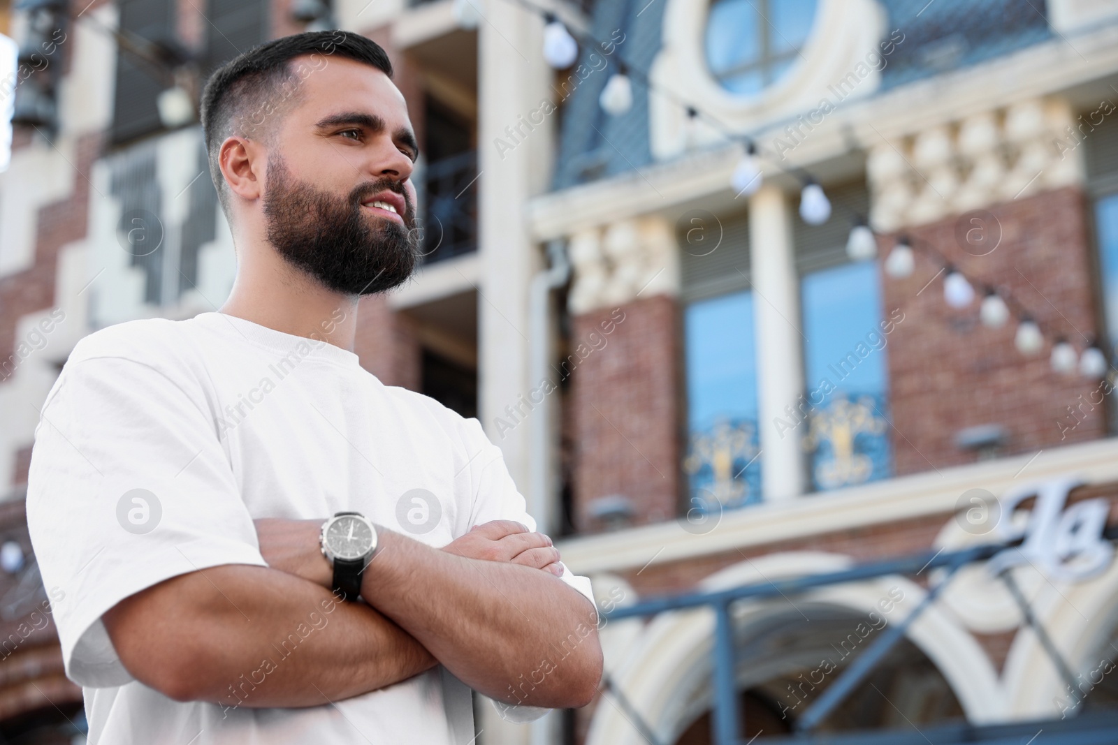 Photo of Portrait of happy handsome man on city street. Space for text