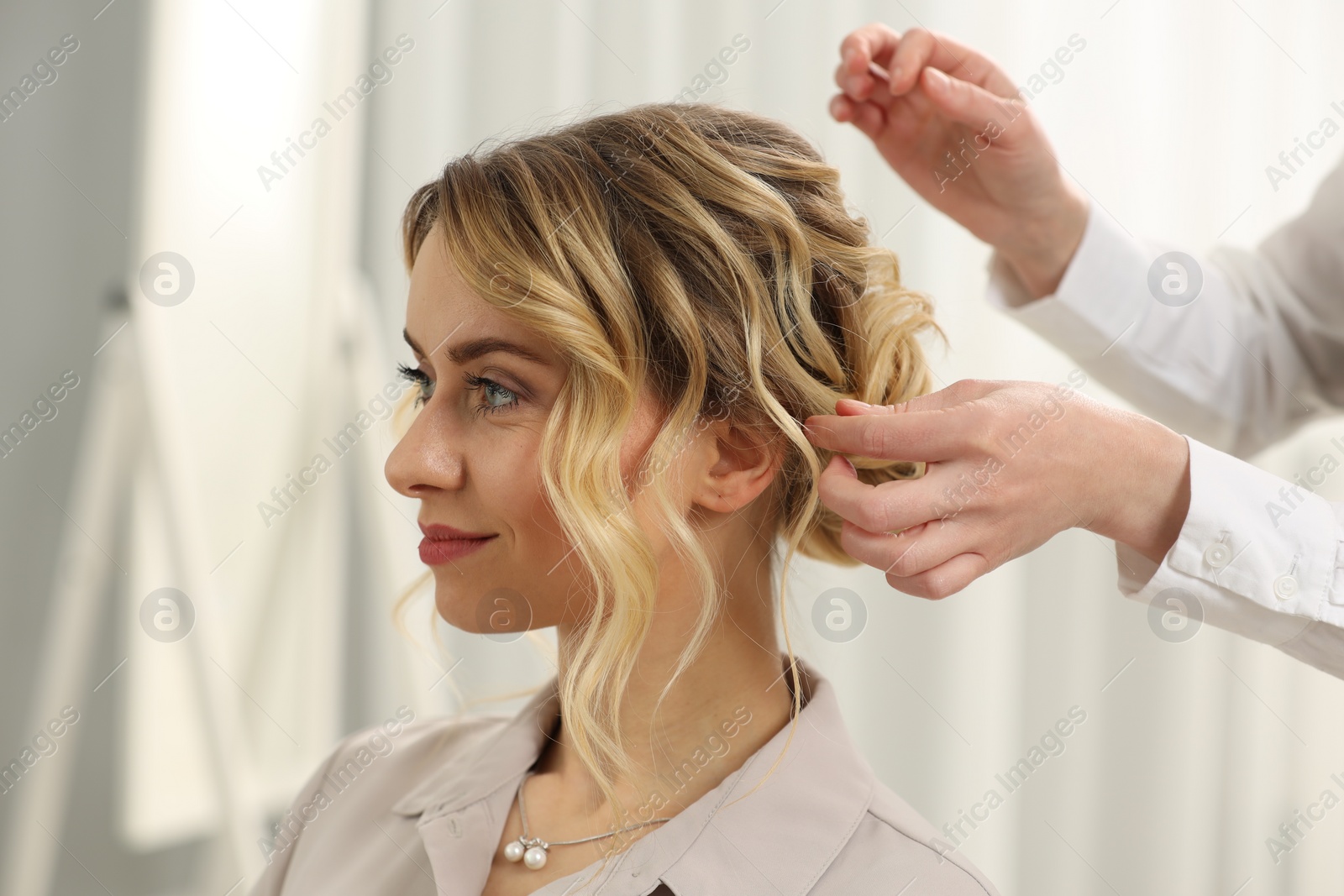 Photo of Hair styling. Professional hairdresser working with client indoors, closeup