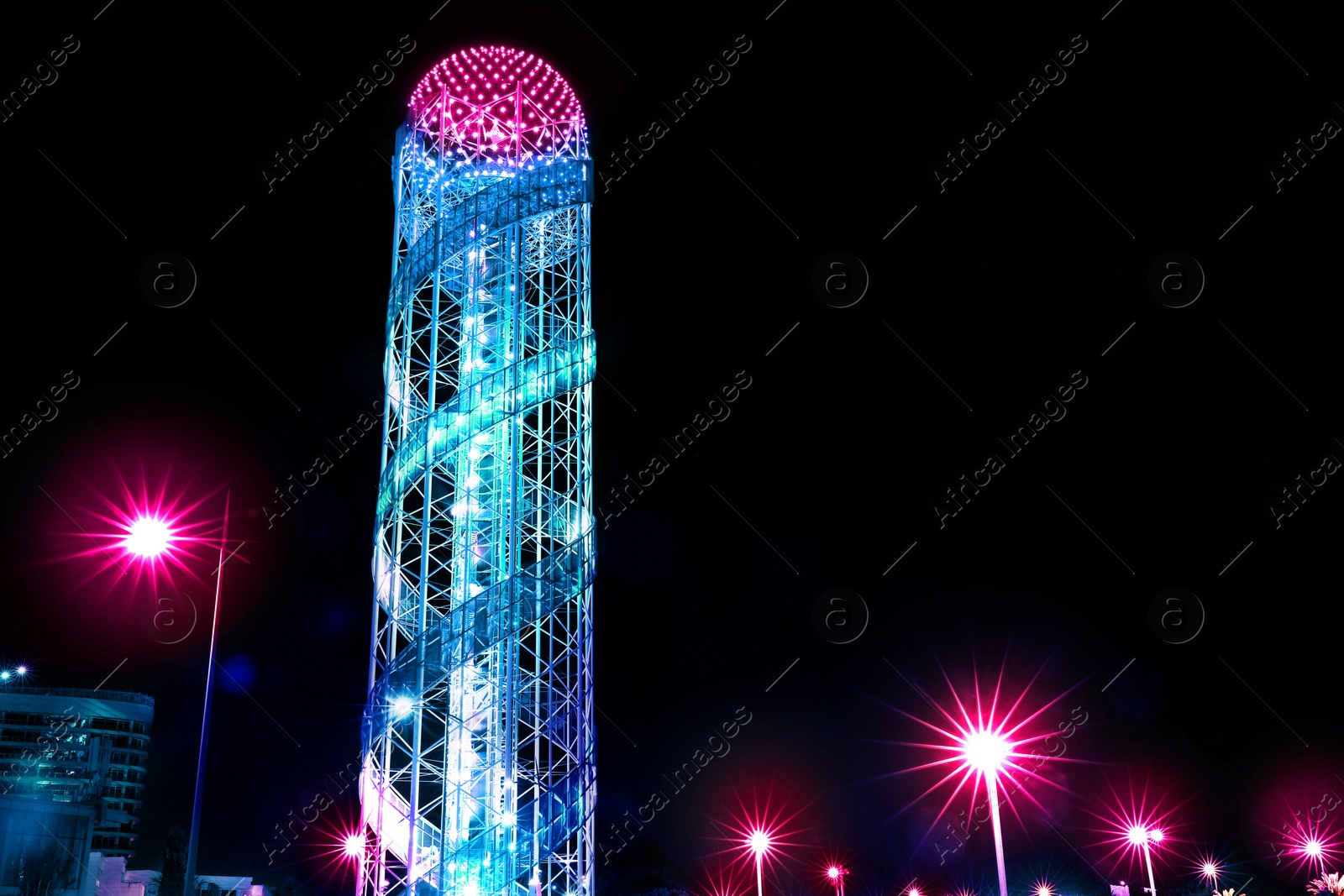 Image of Tower illuminated by beautiful neon lights at night. Modern metropolis