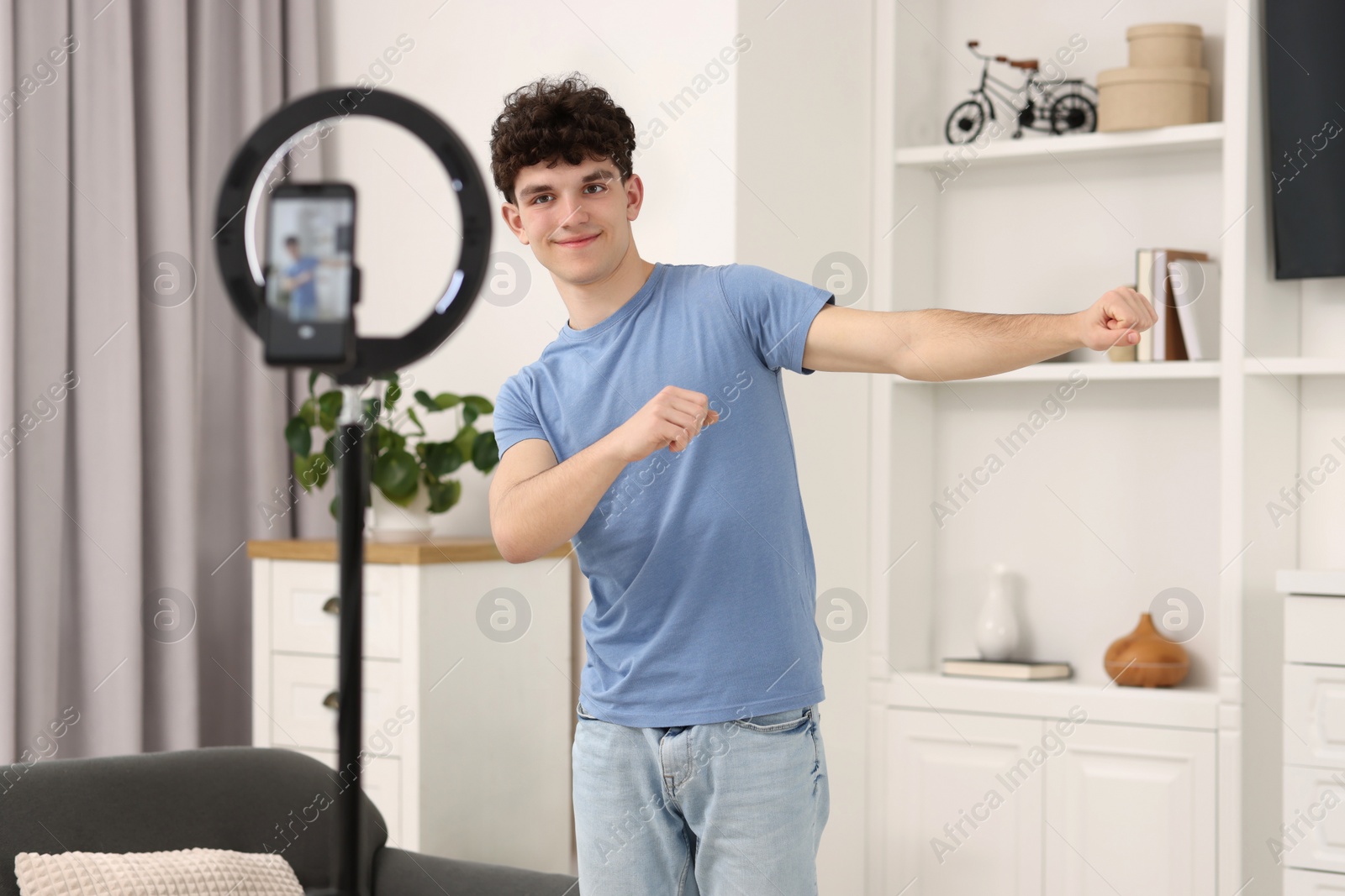 Photo of Teenage blogger dancing while streaming at home