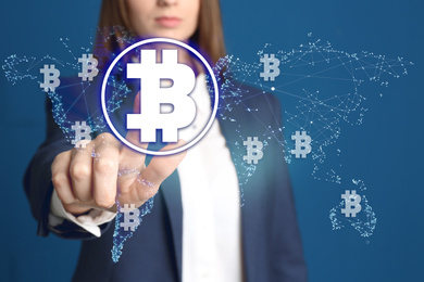 Fintech concept. Woman using virtual screen with bitcoin symbols and world map