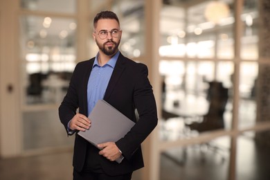 Successful lawyer with laptop on blurred background, space for text