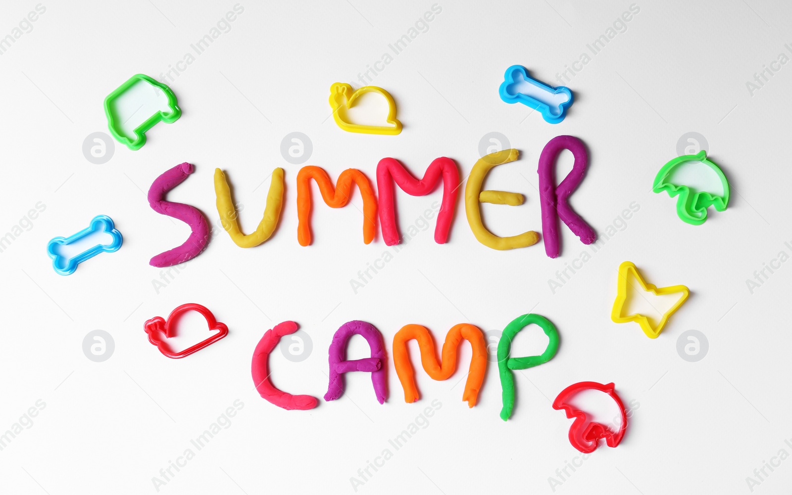 Photo of Flat lay composition with words SUMMER CAMP made from modelling clay on light background