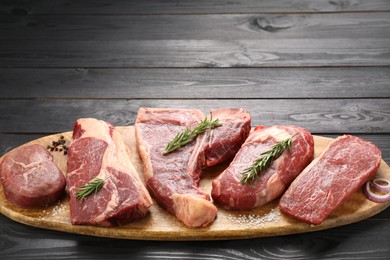 Pieces of raw beef meat on black wooden table